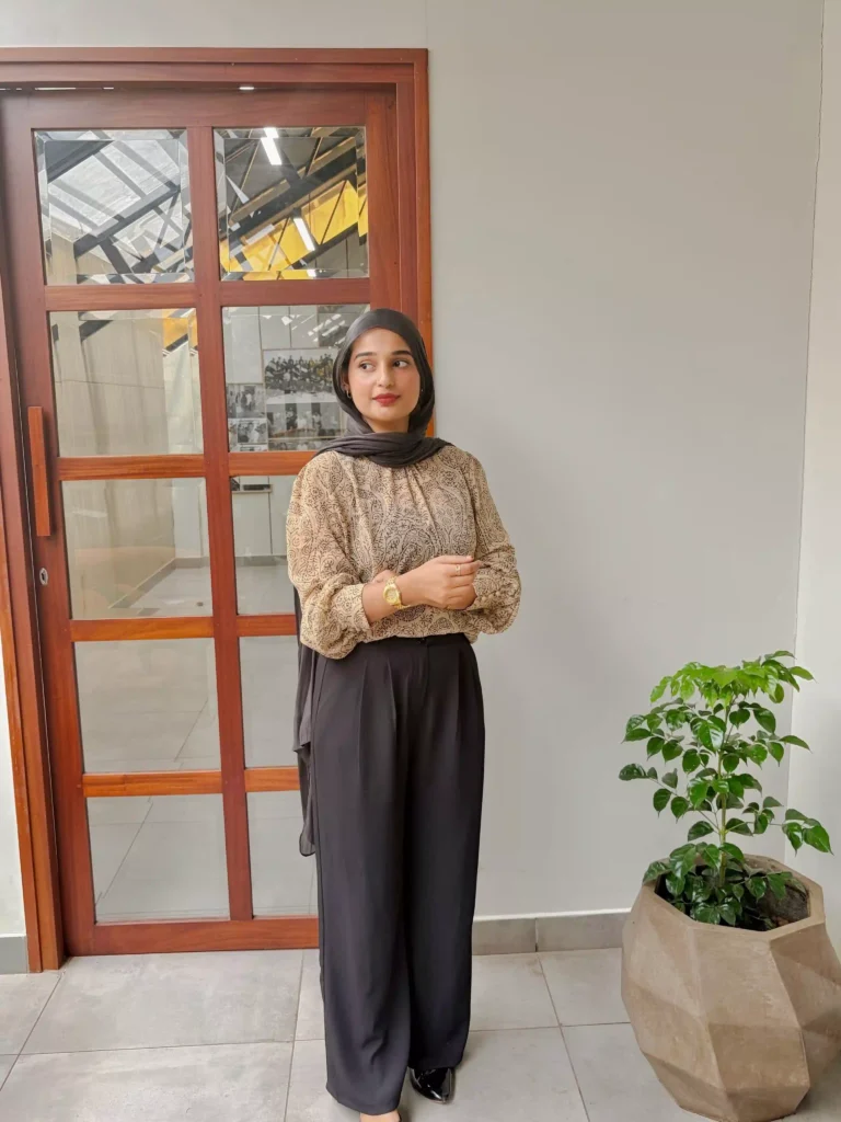 Digital marketing specialist in Kuwait posing in a modern office entrance